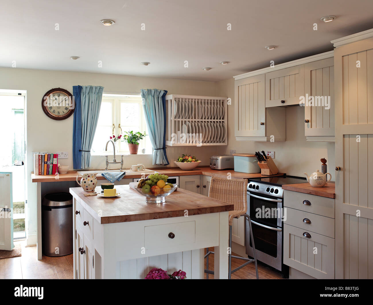 Cocina de estilo shaker con panel blanco alacenas y unidad central de isla  de madera con superficies de trabajo Fotografía de stock - Alamy