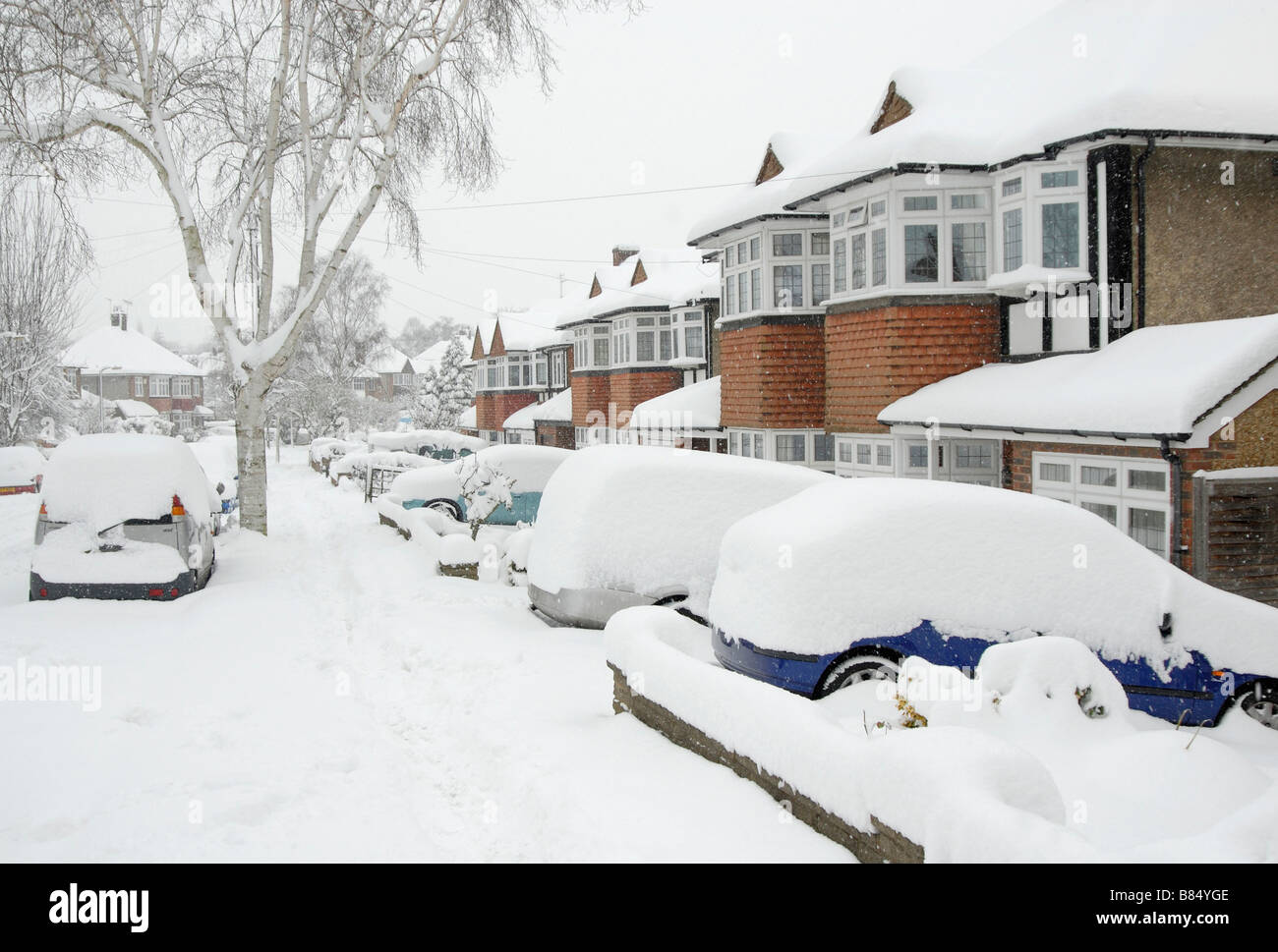 Casas y autos en el suroeste de suburbio de Londres cubiertos de nieve, Sutton, al sur de Londres, Surrey, Inglaterra Foto de stock