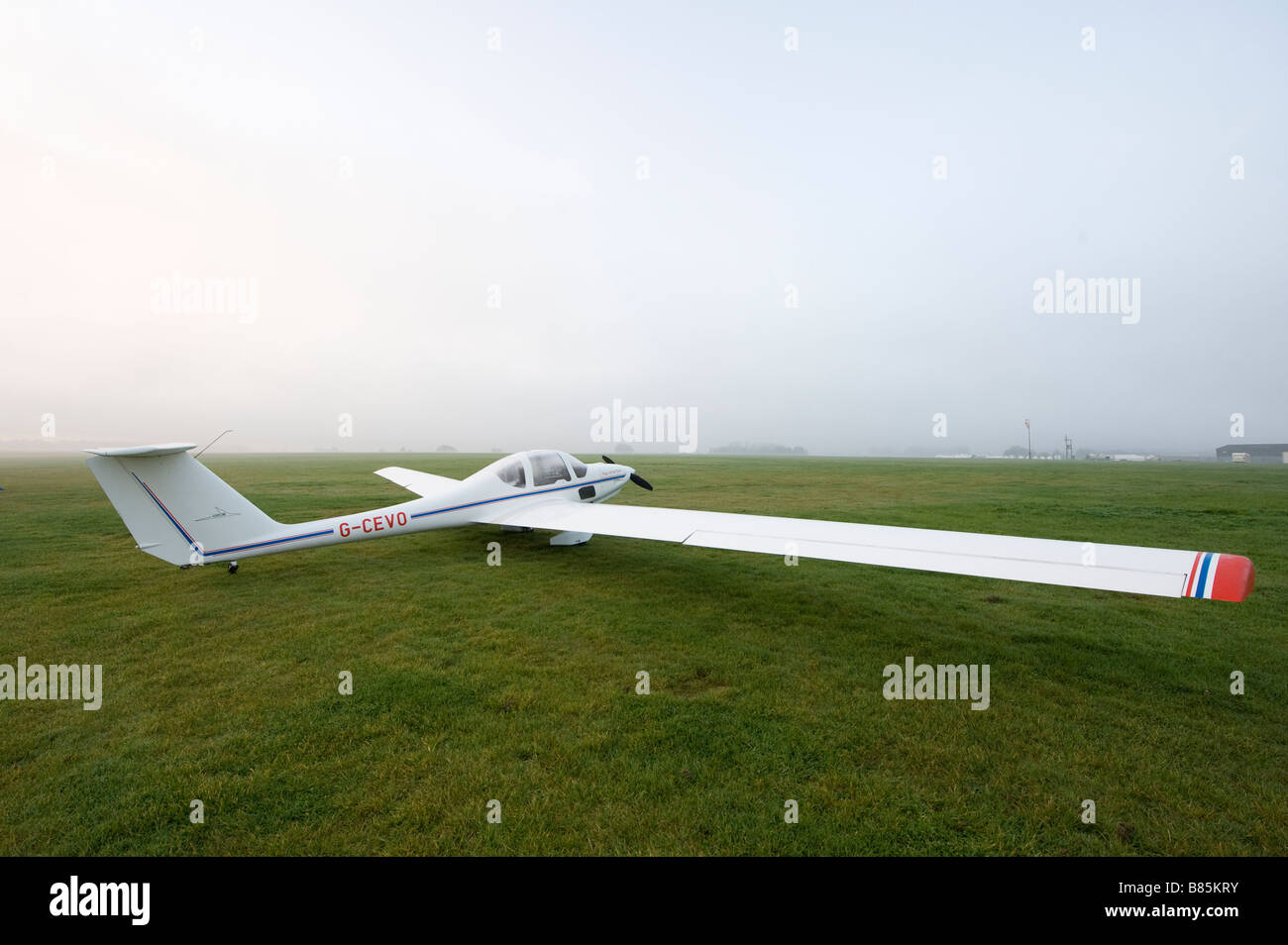 GROB G109B de ala fija auto motor lanzamiento glider esperando en el suelo sobre un misty mañana Foto de stock