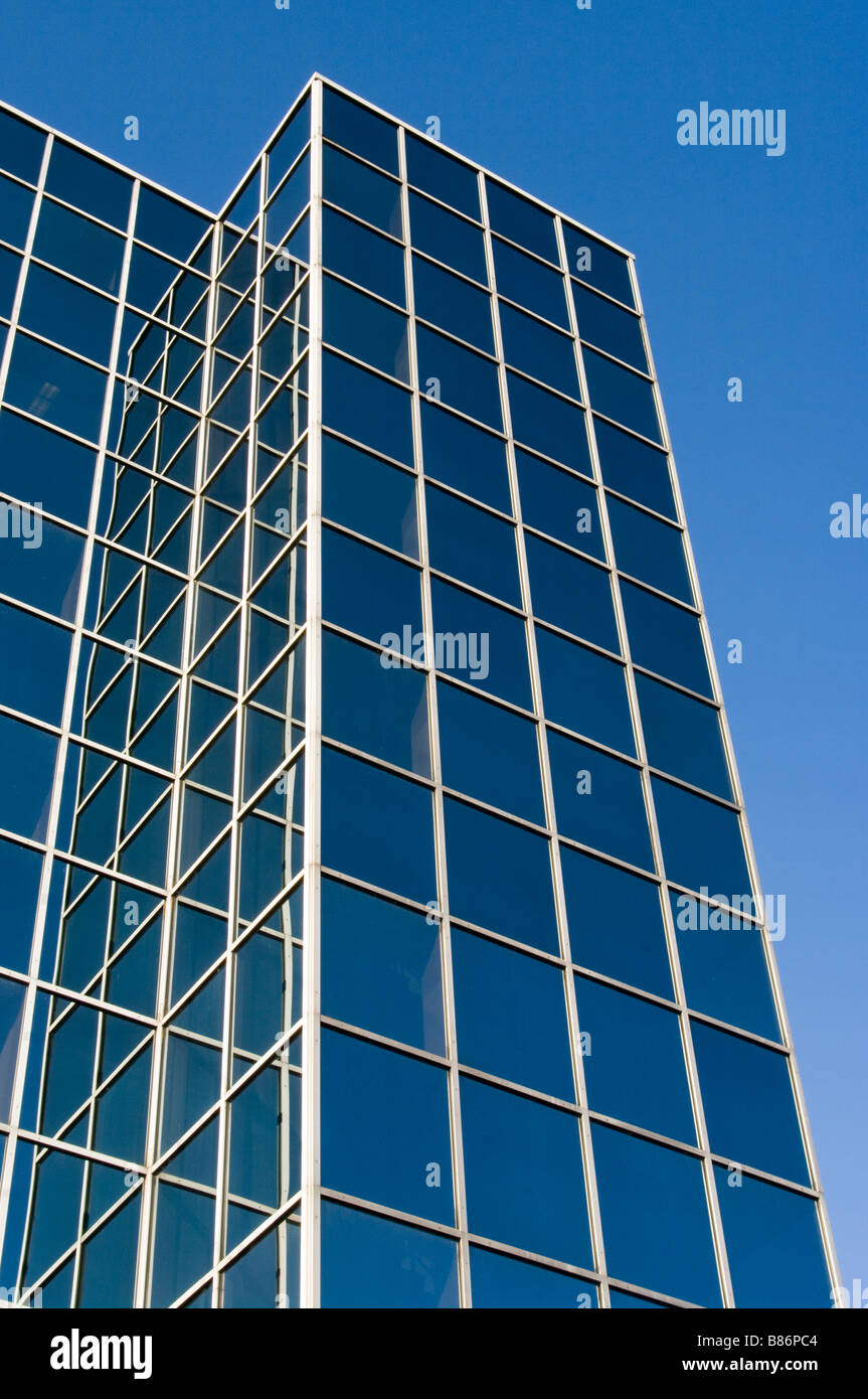 Ventana de cristal fachada de Windows office edificio de oficinas torre contra un cielo azul Foto de stock
