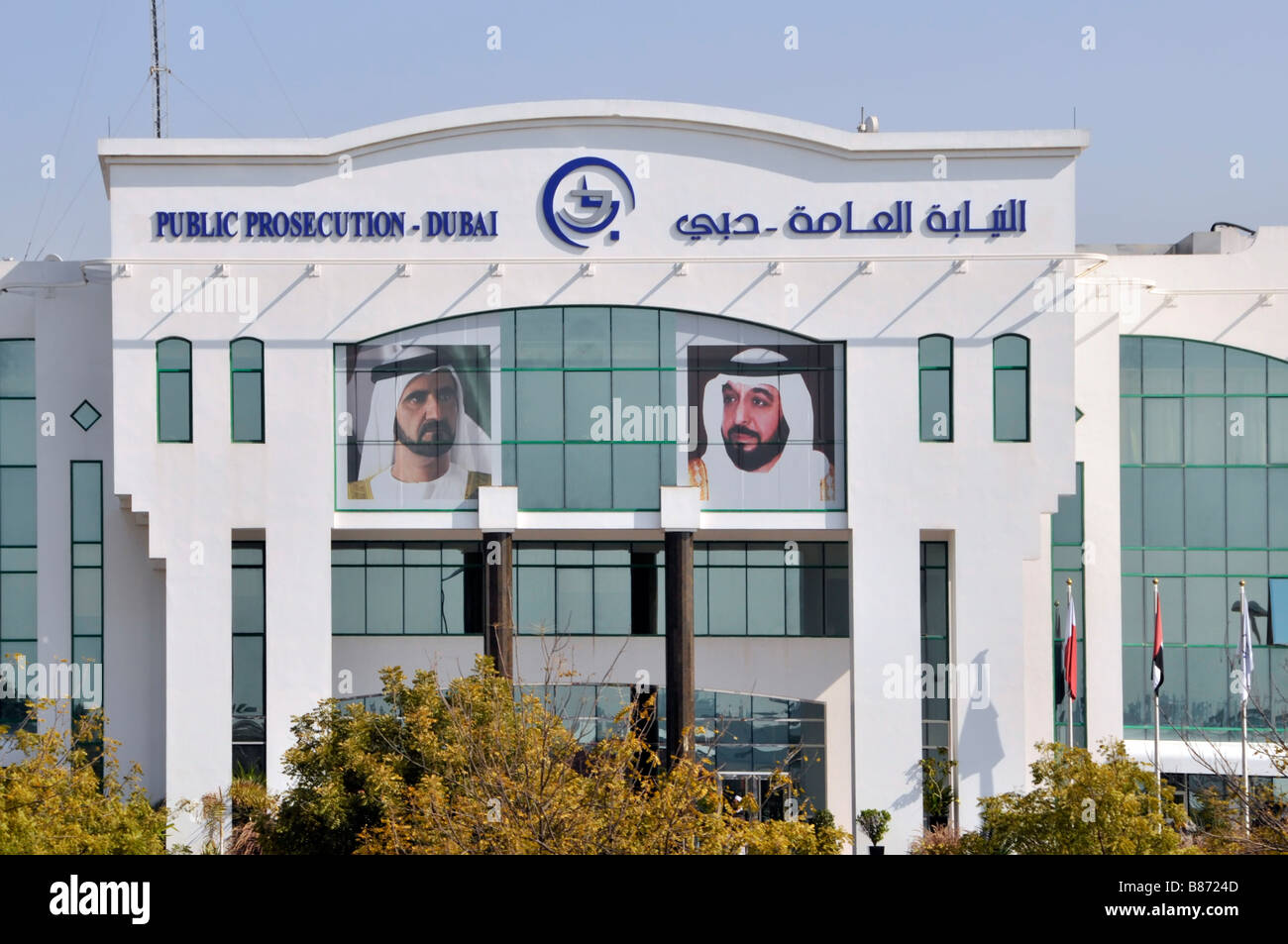 Emiratos Árabes Unidos EAU letreros bilingües sobre la fachada frontal y Entrada del edificio de la Fiscalía Pública del Gobierno de Dubai, retratos y varones cristal tintado Foto de stock