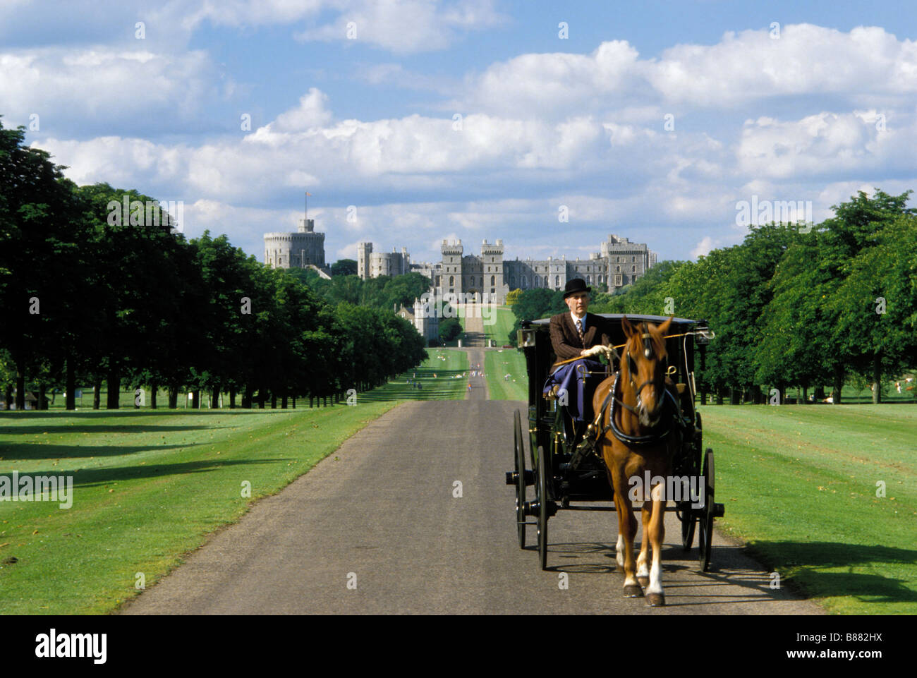 Un adecuado pinstriped caballero vistiendo un sombrero hongo monta un carruaje tirado por caballos. la larga caminata, el castillo de Windsor. Berkshire Reino Unido. Foto de stock