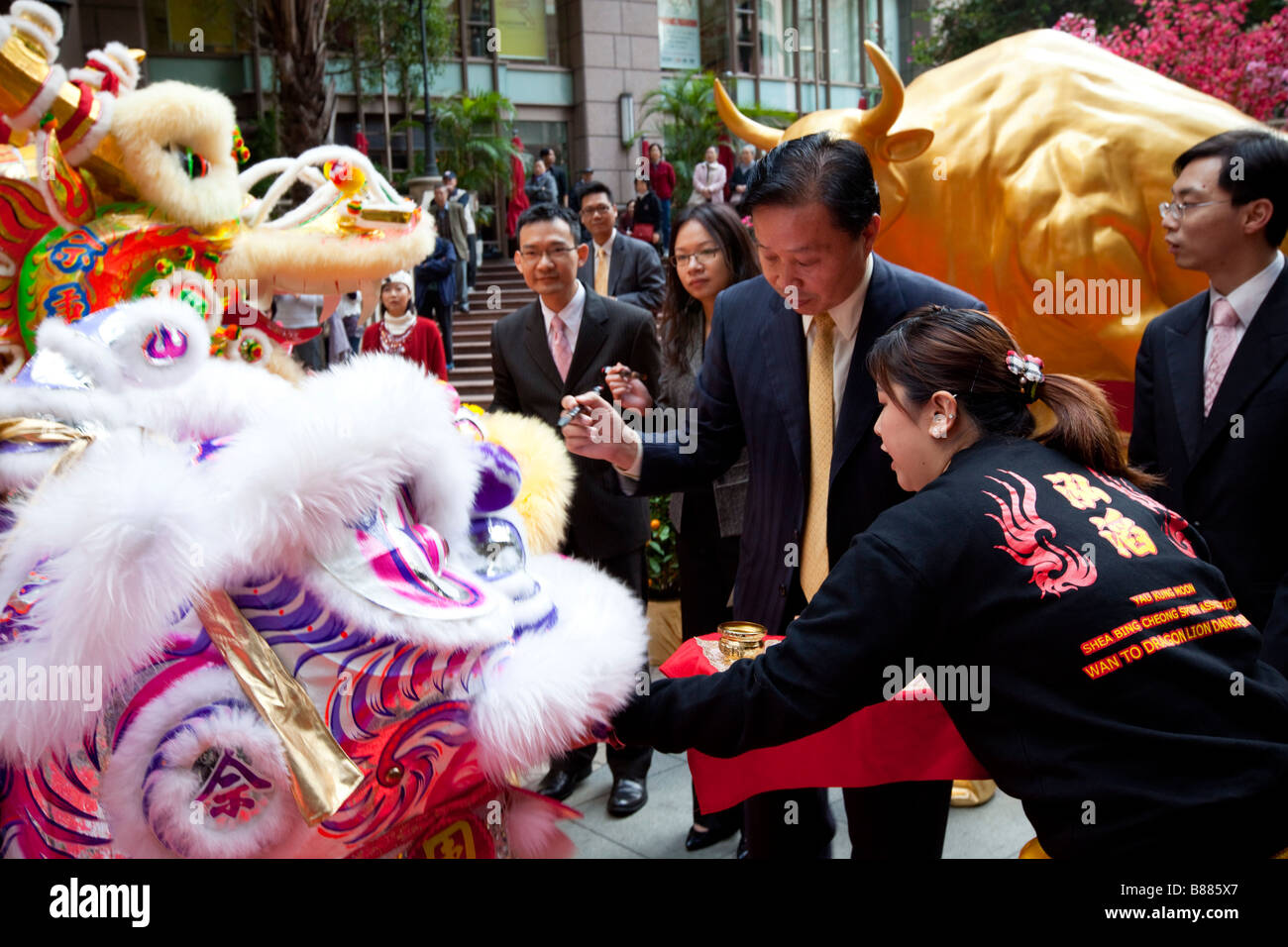 Empresarios de Hong Kong dot los ojos del mítico leones ante un león de la danza tradicional. Foto de stock