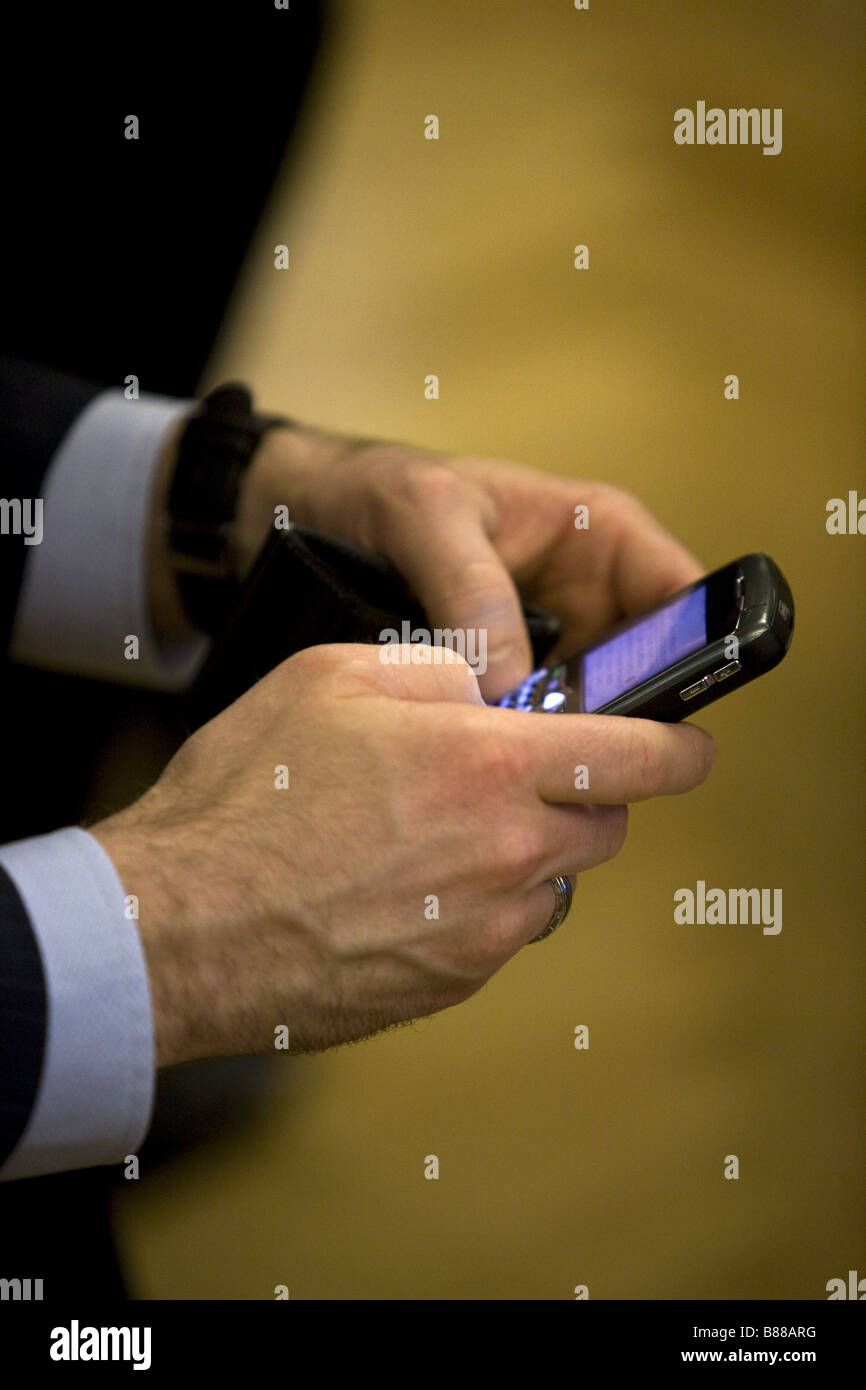 Empresario mensajería de texto desde su teléfono Blackberry. Foto de stock