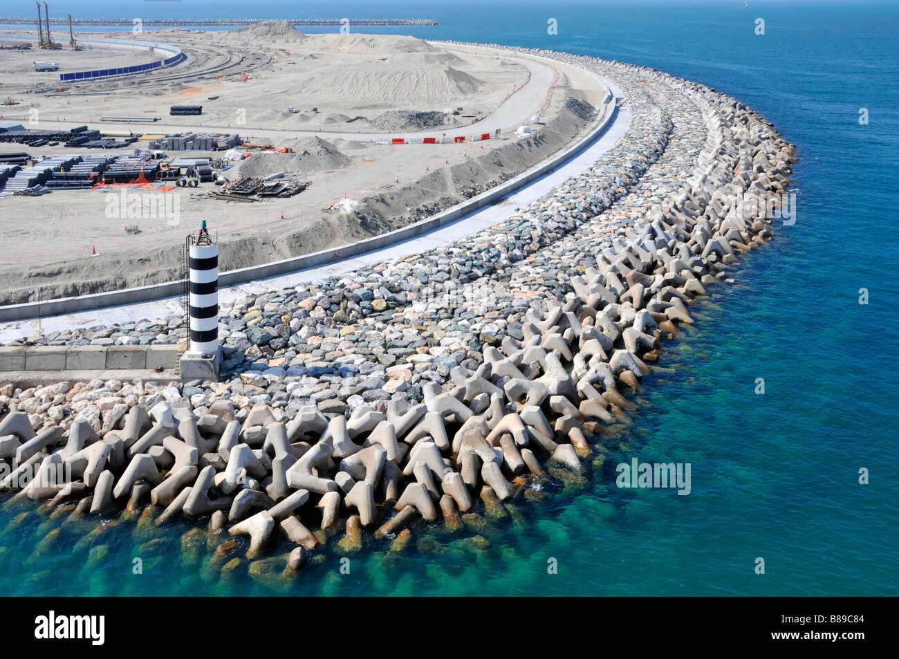 Defensas marinas proyecto de infraestructura civil construcción de sitio para Maritime Ciudad usando bloques de concreto de tipo tetrapod en la costa Dubai UAE Foto de stock