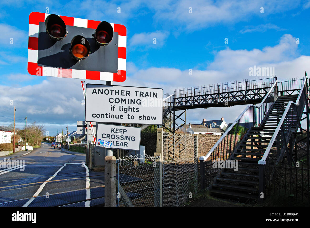Un cruce ferroviario y el puente peatonal cerca de camborne en Cornualles, Reino Unido Foto de stock