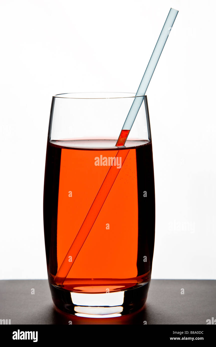 Bebida de color rojo en el vidrio con paja Foto de stock