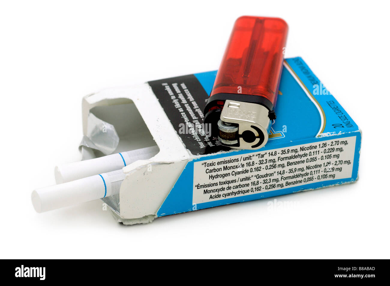 Paquete de cigarrillos y un encendedor. Panel lateral muestra emisiones tóxicas por unidad. Foto de stock