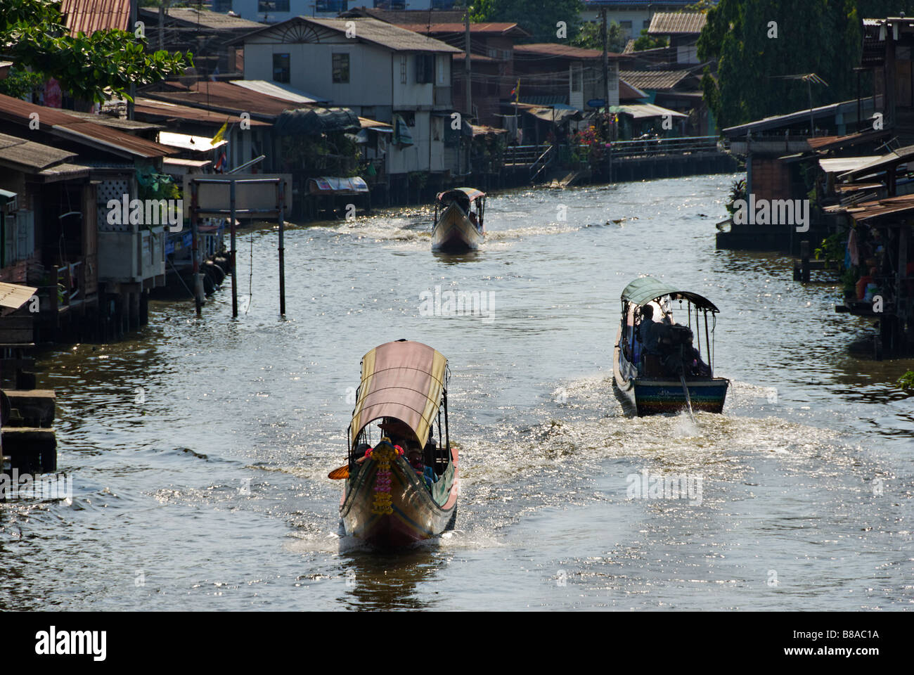 Larga cola de barcos de pasajeros que viajan a lo largo de Khlong Mon canal río Thonburi distrito en Bangkok, Tailandia Foto de stock