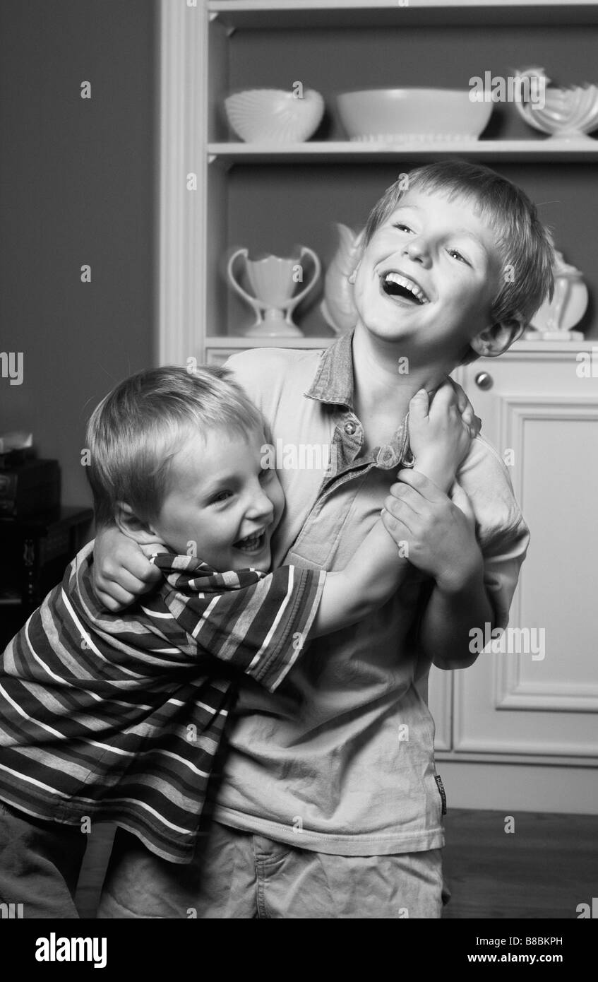 Hermanos jugando riendo, B/W Foto de stock