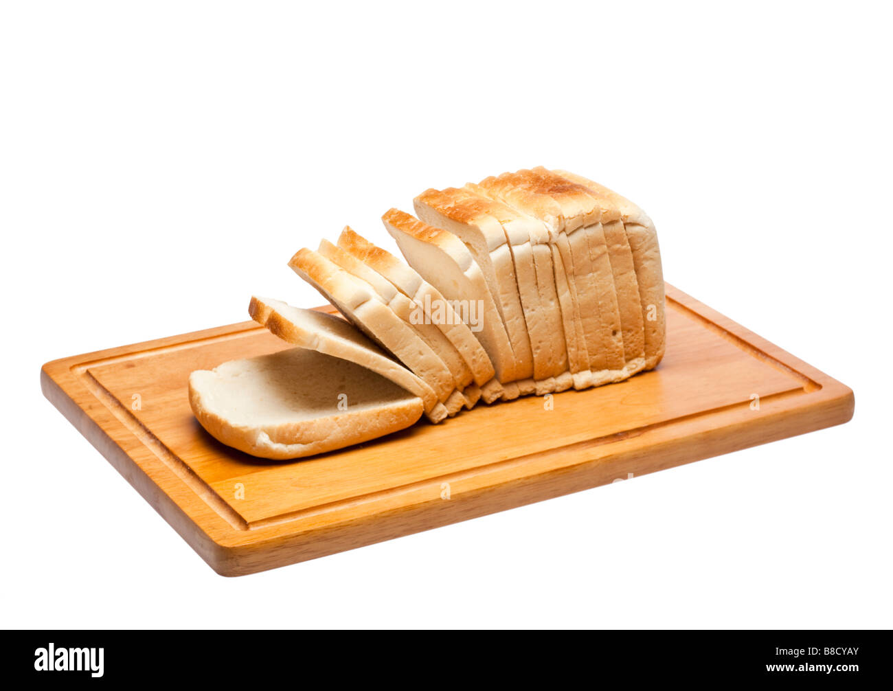 Hogaza de pan blanco en rodajas de pan de madera junta sobre blanco Foto de stock