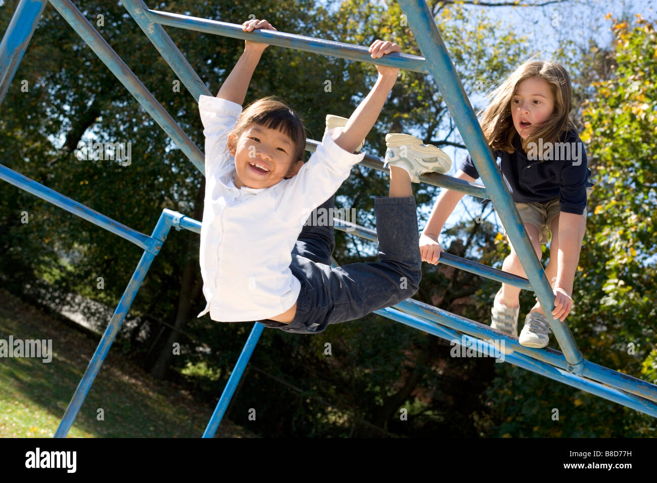 Los alumnos de la escuela elemental jugando en un patio de recreo. Foto de stock