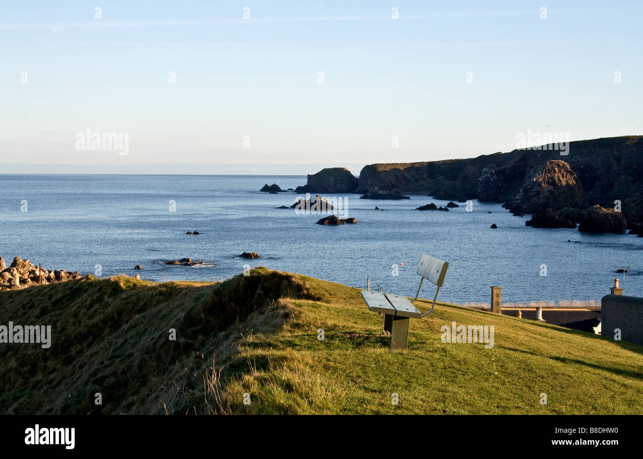 Banco sobre una playa rocosa con vistas a Moray Firth en Escocia Findochty Foto de stock