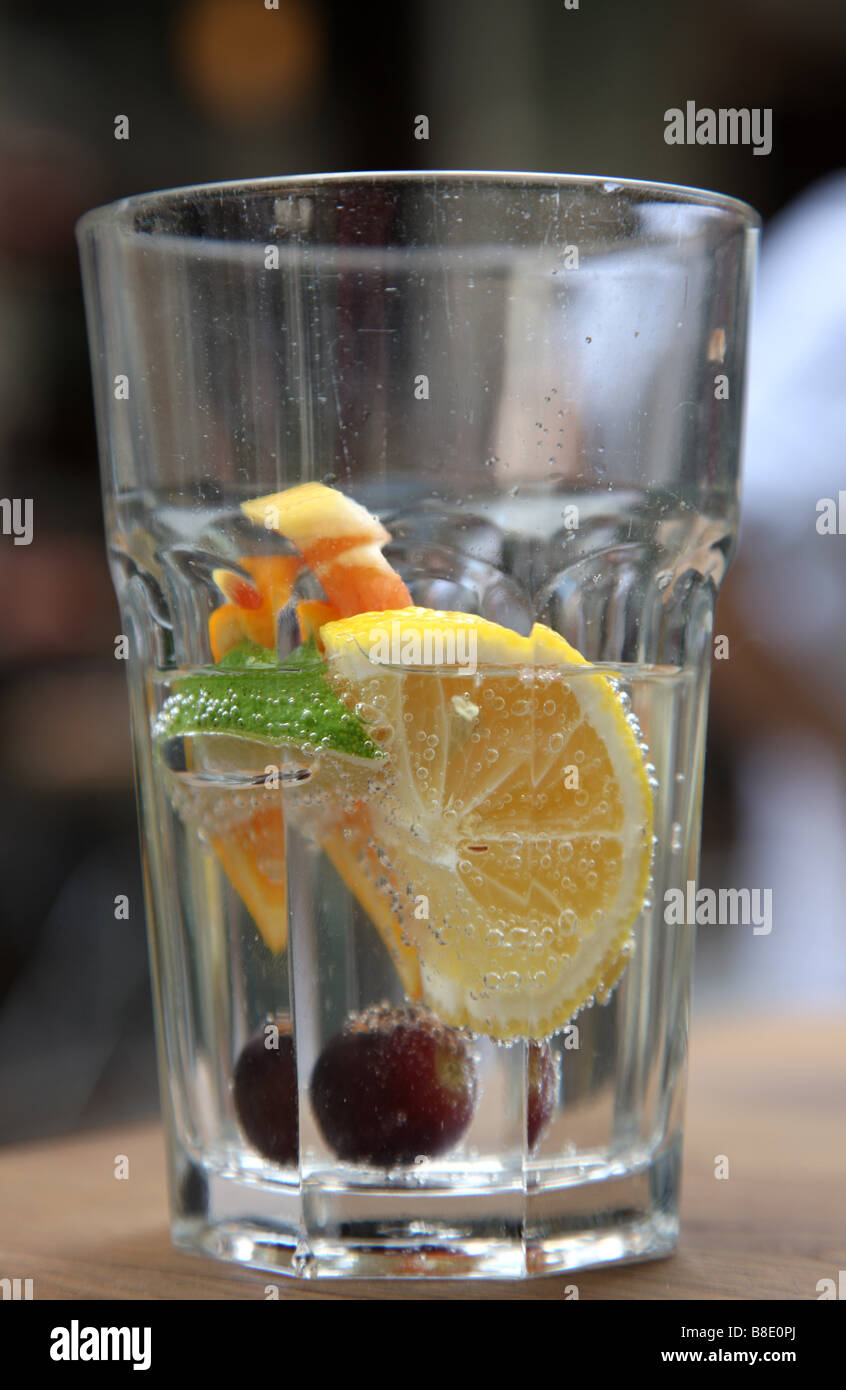 Vaso con agua mineral y frutas cítricas. Foto de stock