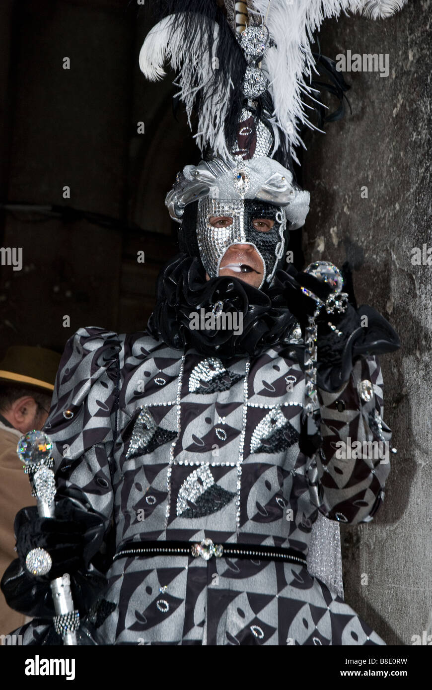 Disfraz de carnaval veneciano con una máscara de negro y plata penachos  negros y guantes cerca de una lámpara de la calle en San Marcos Fotografía  de stock - Alamy