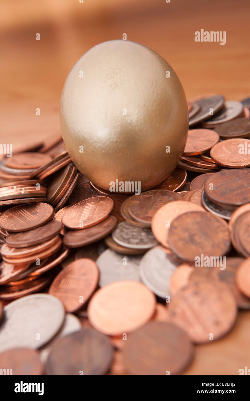 Huevo de Oro anidado en el montón de monedas Foto de stock