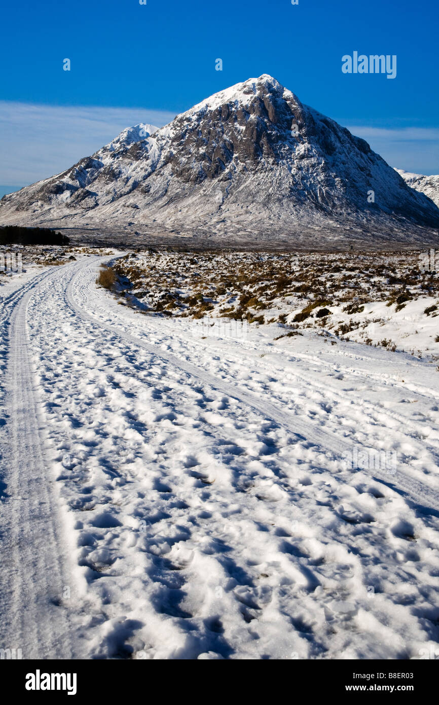 Un camino cubierto de nieve a través de Rannoch Moor hacia Buachaille Etive Mor, Lochaber, Escocia. Foto de stock