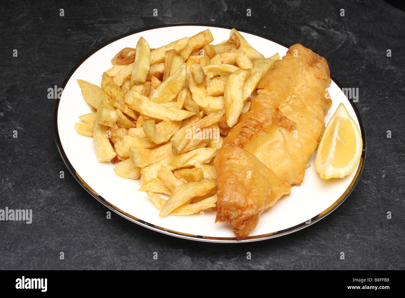 Fish and Chips de tomar distancia con una rodaja de limón. Foto de stock