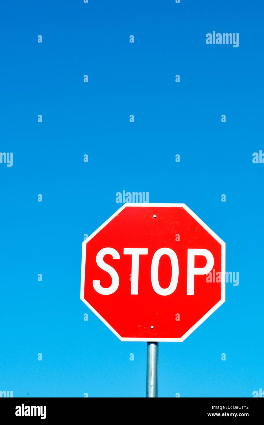 Señal de Stop rojo y blanco contra el profundo azul cielo claro imagen gráfica Foto de stock