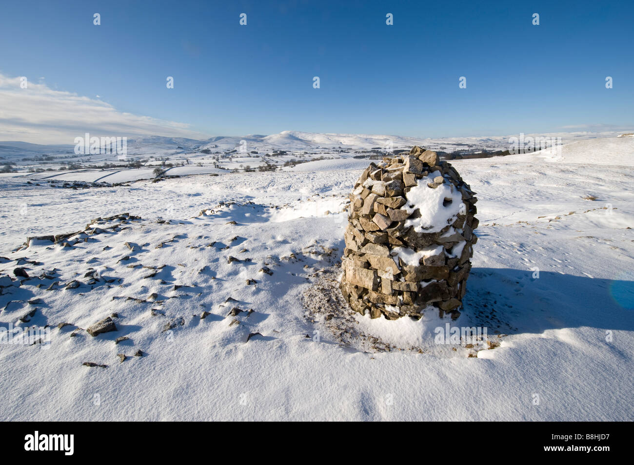 Mojón de piedra cubiertas de nieve en Ash cayó cerca perimetral Ravenstonedale mirando hacia el norte extremo oriental de Cumbria Fells Howgill Foto de stock