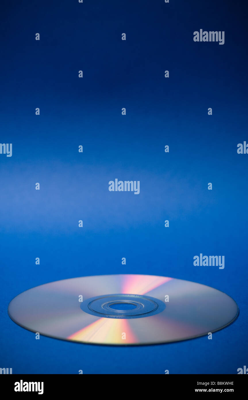 Un disco compacto sobre un fondo azul. Foto de stock