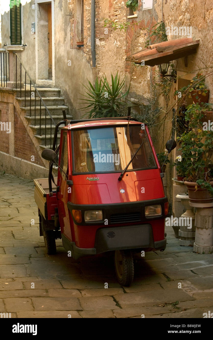 Rojo 3 ruedas carretilla granja llamado 'ape' en italiano, lo que se traduce como abeja en contraposición a la "Vespa scooter' que es una avispa Foto de stock