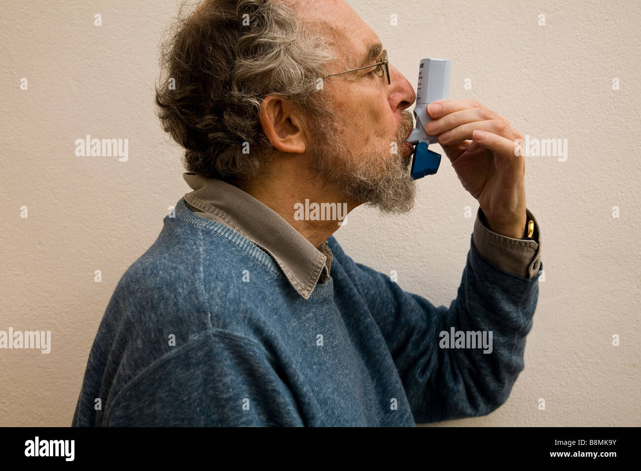 Ancianos sufre de asma usando el inhalador Salbutamol Foto de stock