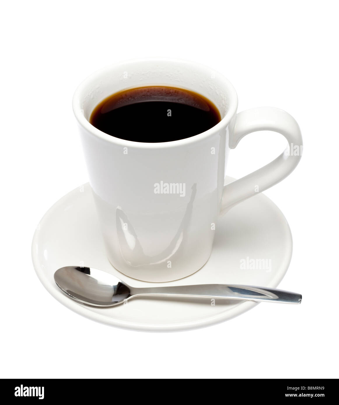 Taza de café negro sobre el platillo con cuchara en recorte de blanco Foto de stock