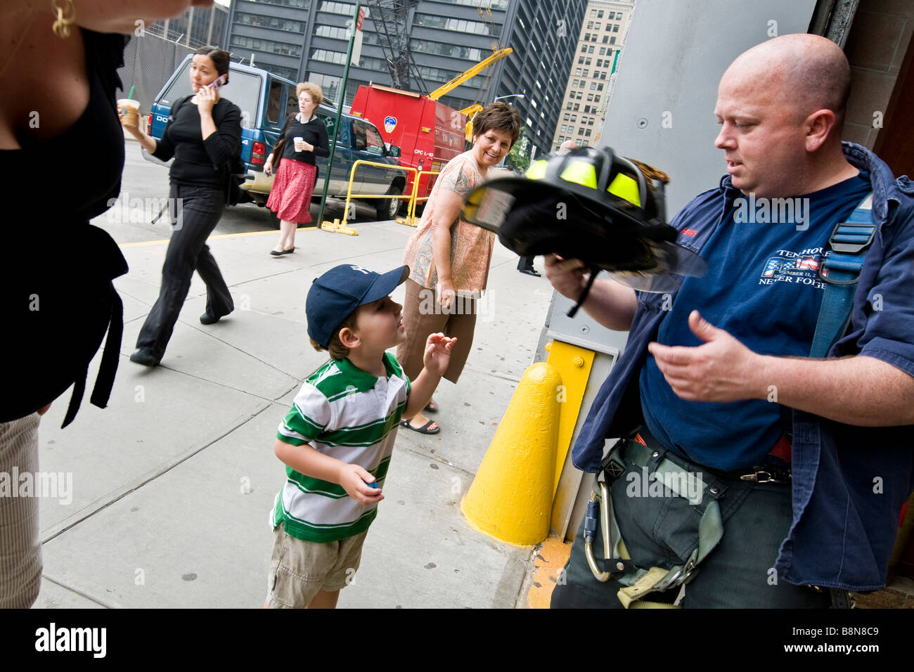 Joven hablando a bombero fuera del departamento de bomberos de la ciudad de Nueva York. Foto de stock