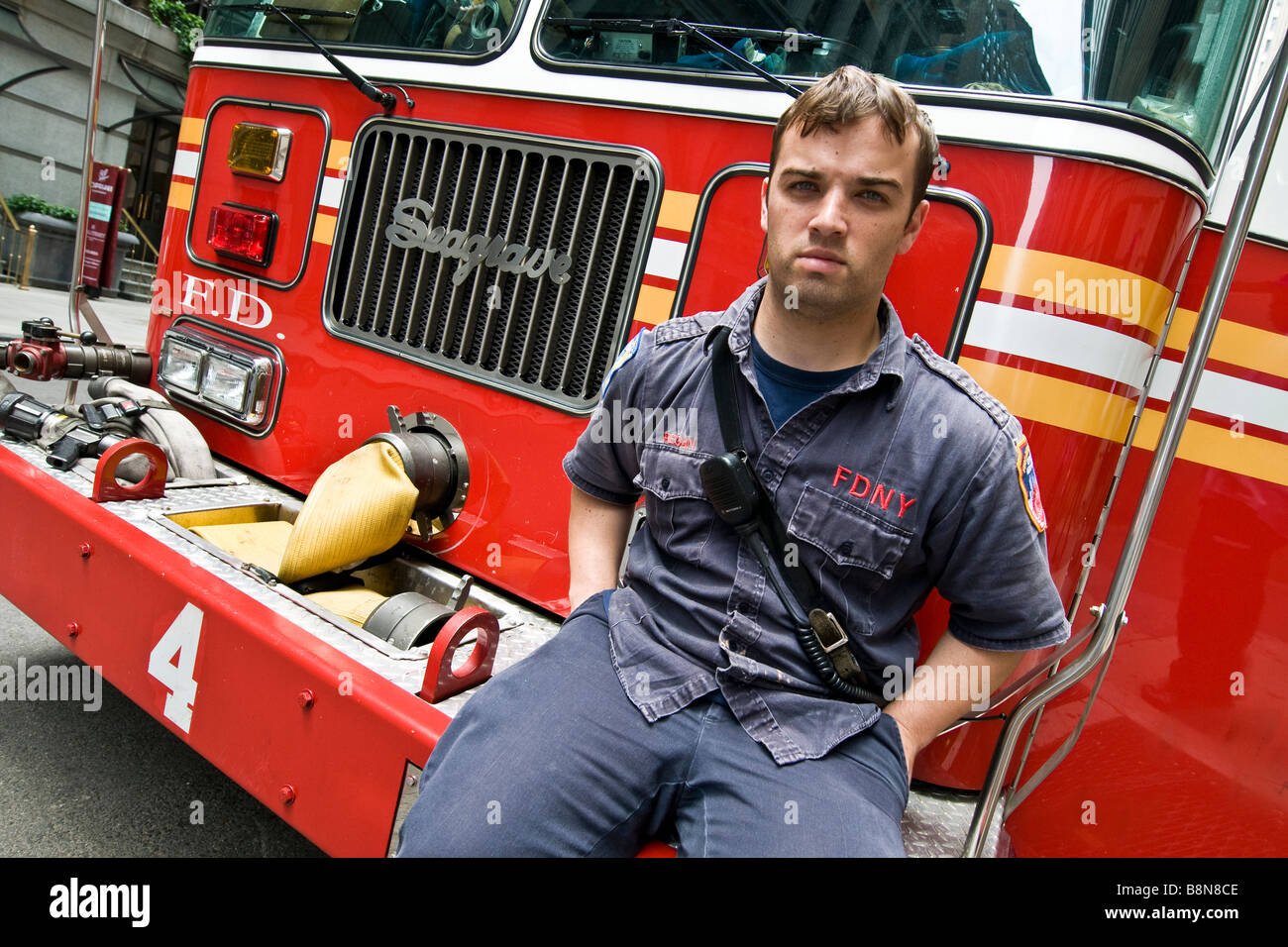 La ciudad de Nueva York bombero sentado en la parte delantera del camión de bomberos Foto de stock