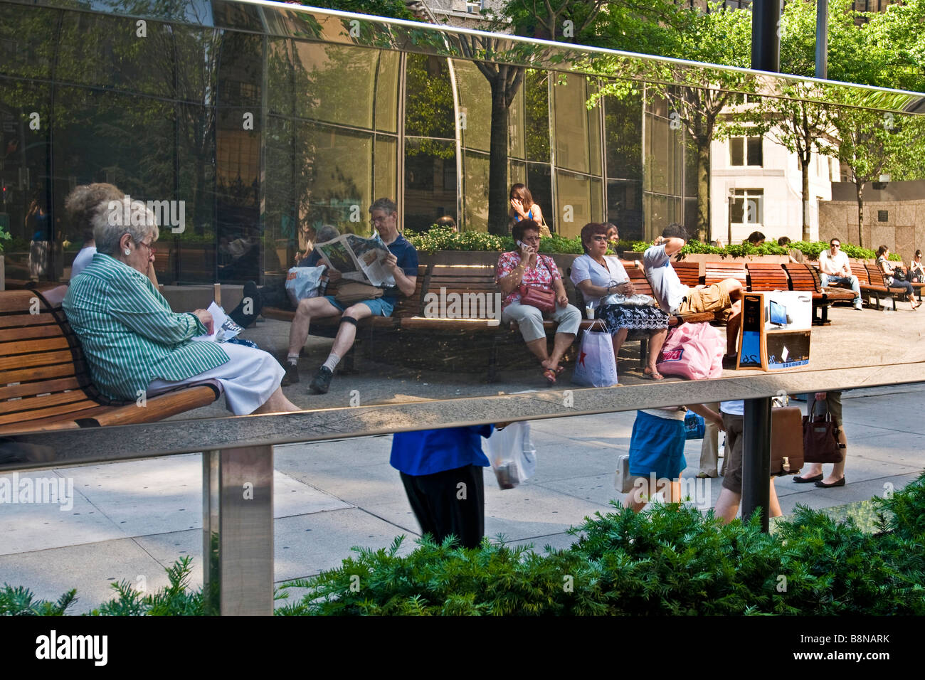 Escena urbana con personas sentadas en los banquillos Foto de stock