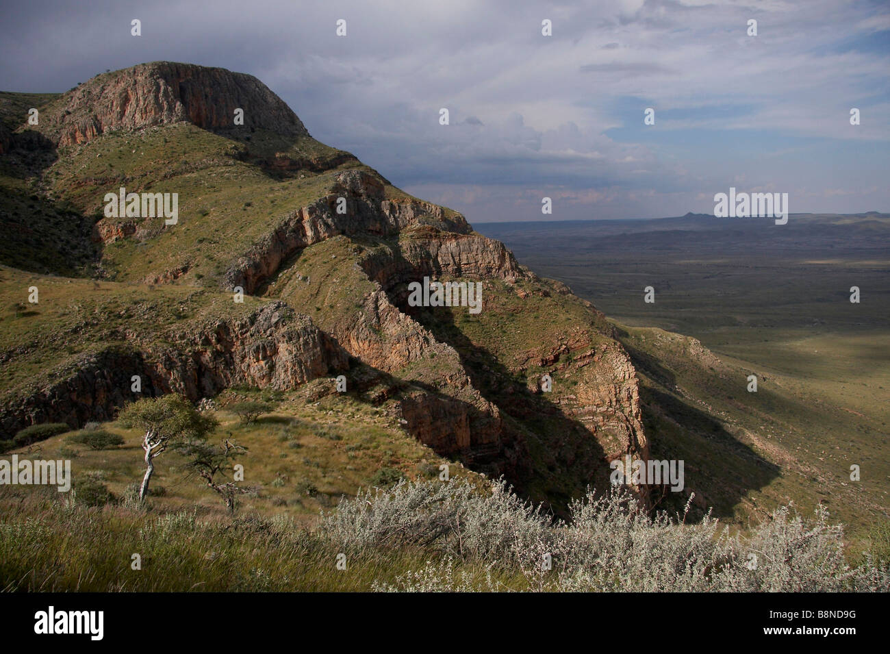 Paisaje de Namibia mostrando las crestas de las montañas rocosas en el primer plano y llanuras de abajo Foto de stock