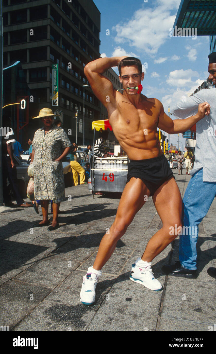 Un amante de la diversión, bare chested músculo hombre con un clavel en sus  dientes el día de San Valentín en las calles de Johannesburgo Fotografía de  stock - Alamy