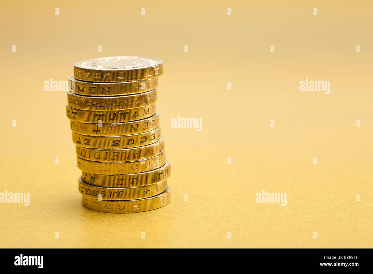 Pila de £1 monedas de una libra esterlina sobre fondo de oro Foto de stock