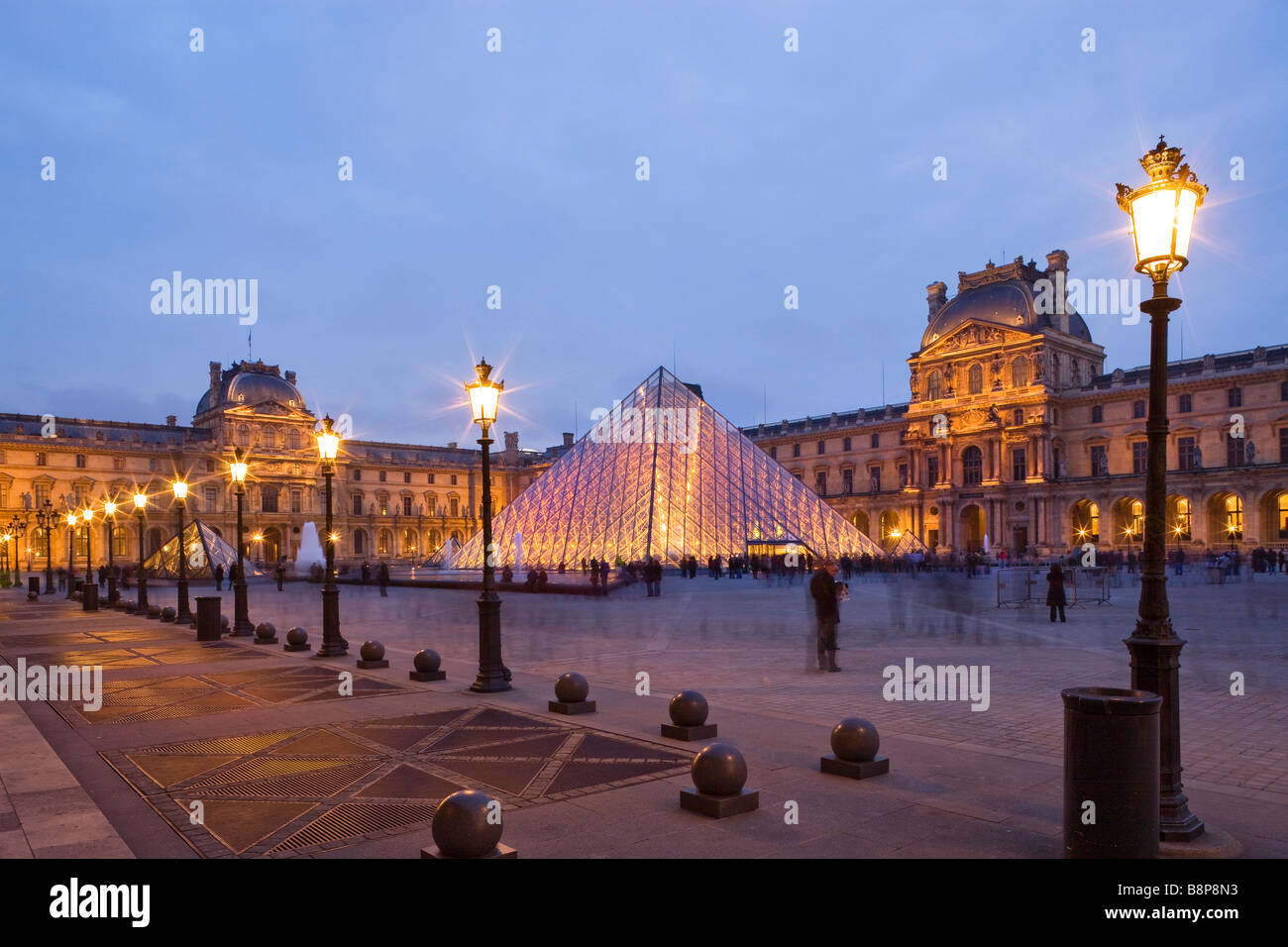 Museo del Louvre pirámide de cristal iluminado entrada París Francia Foto de stock