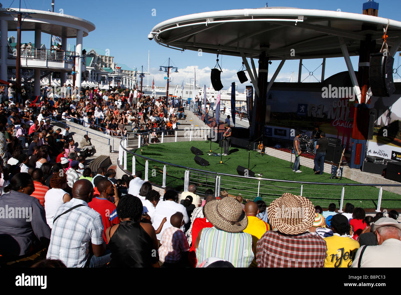 Multitud viendo una banda en vivo en el V&A Waterfront anfiteatro Cape Town South Africa Foto de stock