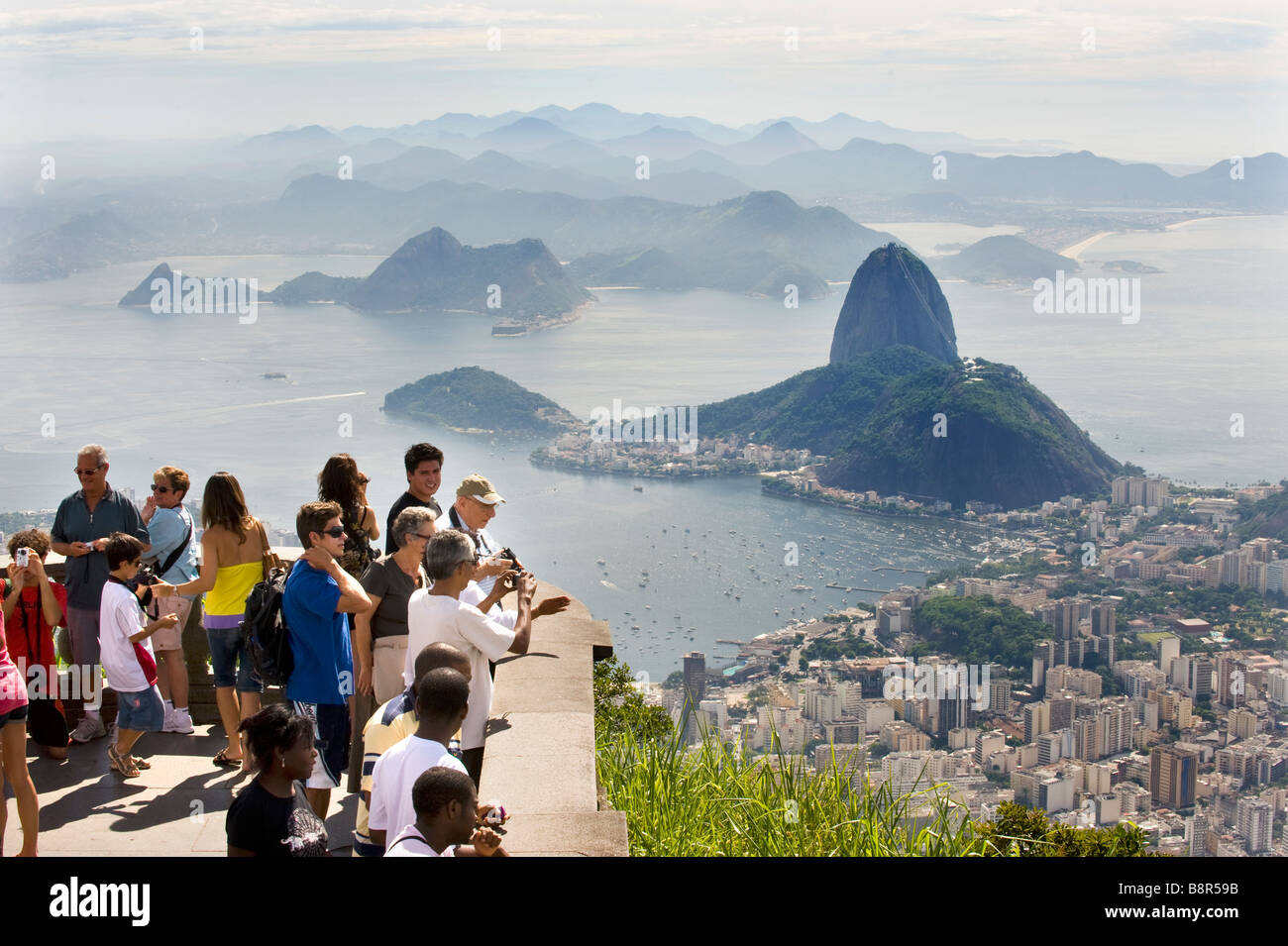 Los turistas de RÍO DE JANEIRO, vista desde la colina de Corcovado, debajo de la estatua de Cristo Redentor mirando hacia SUGARLOAF MOUNTAIN Foto de stock