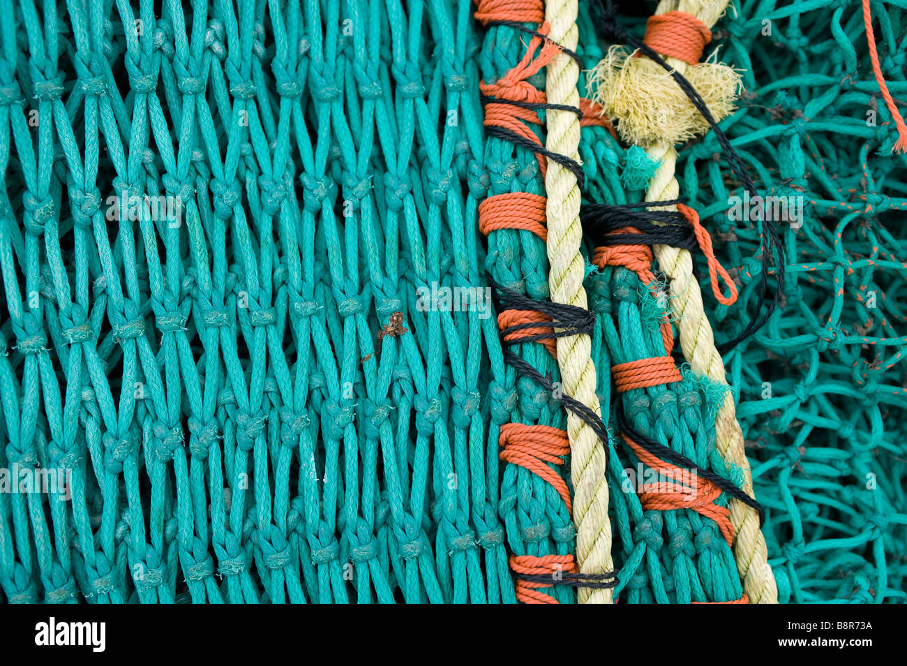 Una de las redes de pesca, cinturón verde amarillo naranja resumen cerca detalles en una red de pesca Foto de stock