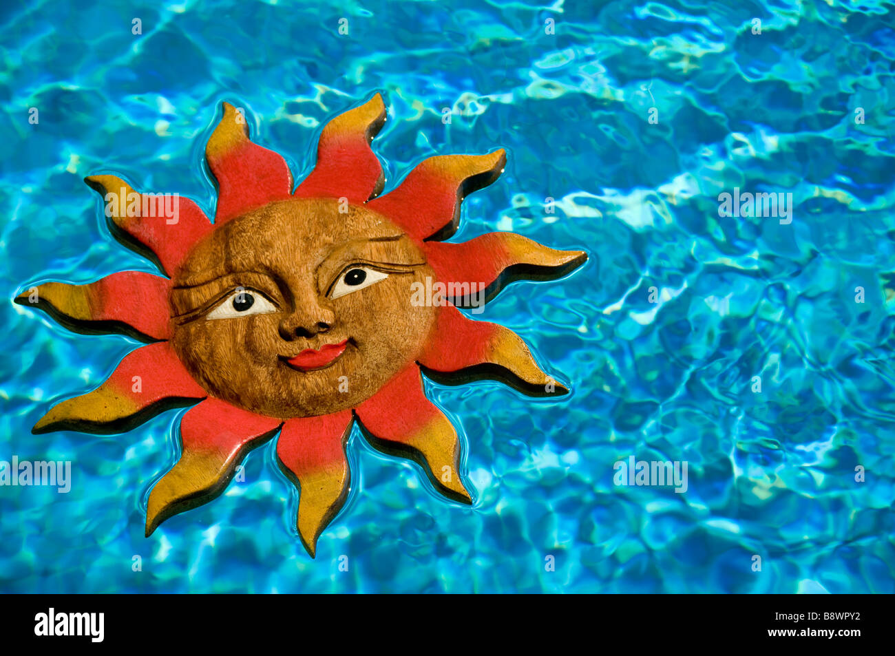 Icono de cara sonriente sol flotando en soleadas vacaciones azul piscina ajuste Foto de stock