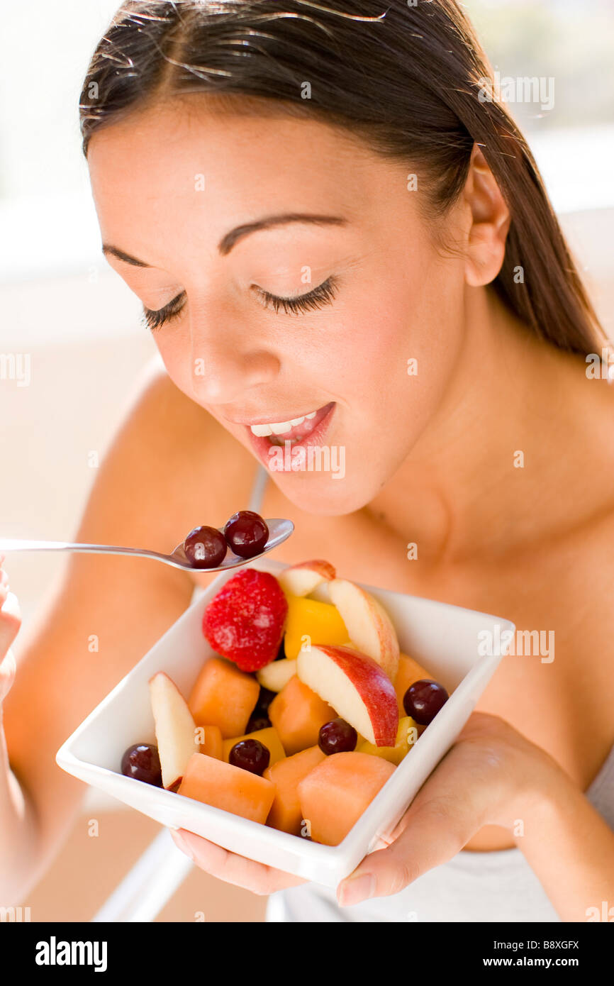 Mujer disfrutar comer ensalada de frutas Foto de stock