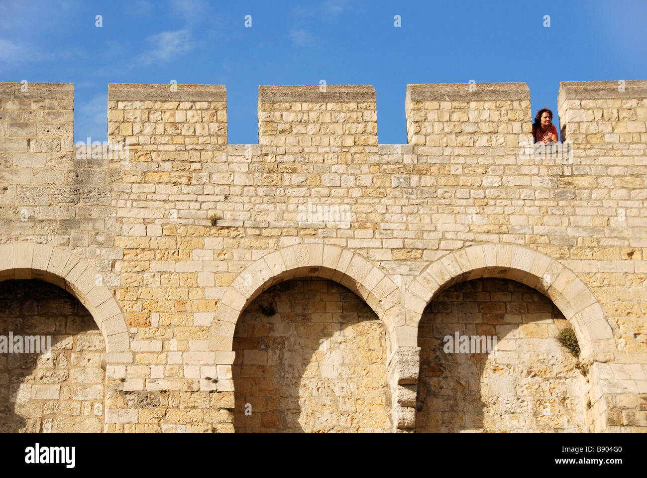 La mujer en la muralla del castillo, San Maries de la Mer, Francia Foto de stock