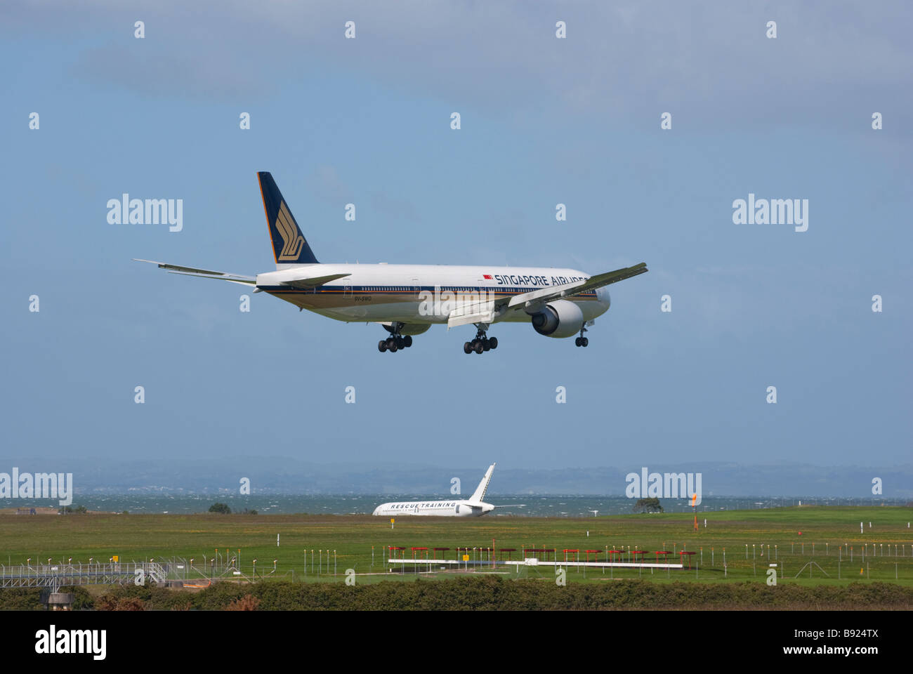 Boeing 777-312ER de Singapore Airlines el acercamiento final para aterrizar en el aeropuerto internacional de Auckland. Foto de stock