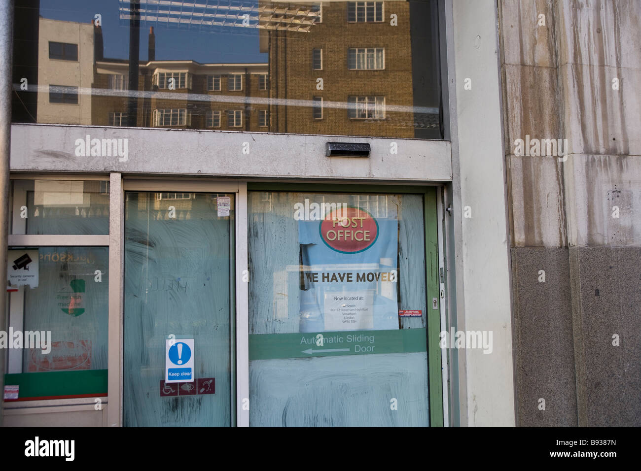 Cerraron una oficina de correos con el poste rojo símbolo y logotipo en la ventana Foto de stock