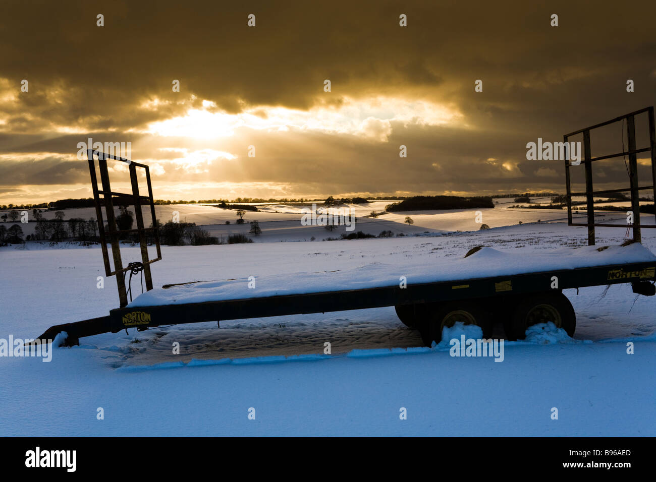 Una puesta de sol de invierno en la nieve en los Cotswolds en Turkdean, Gloucestershire Foto de stock