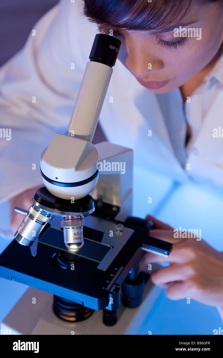 Un hermoso asiático femenino investigador médico o científico utilizando su microscopio Foto de stock