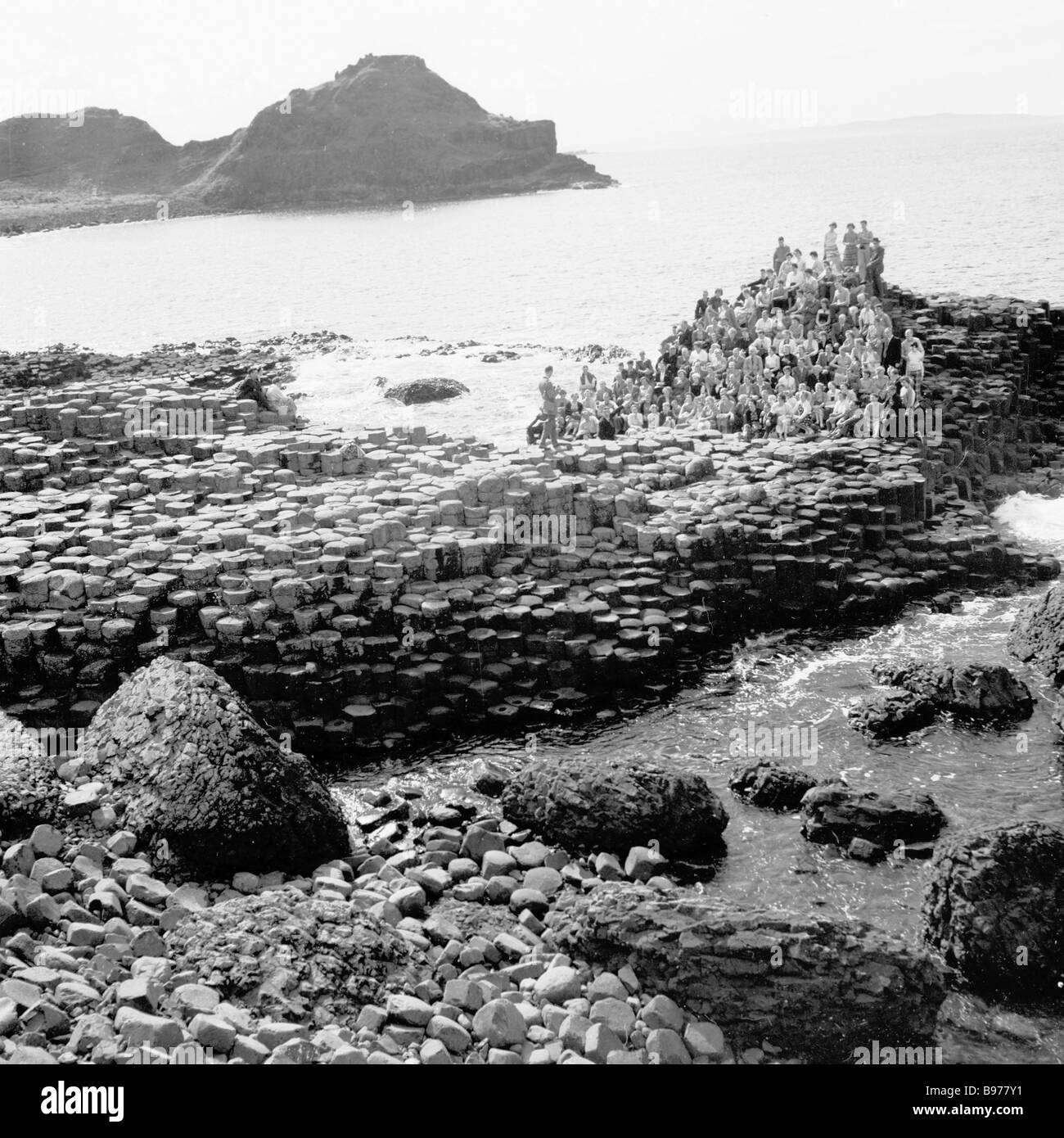 1950s, históricos, grupo de personas sobre las antiguas formaciones rocosas, las columnas de basalto, en el famoso Giant's Causeway, Co. de Antrim, Irlanda del Norte. Foto de stock