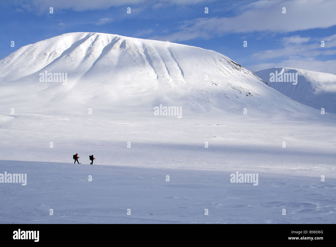 Dos personas raquetas de nieve lejos en la distancia en el Kungsleden Dentro del Círculo Polar Ártico en el norte de Suecia Foto de stock