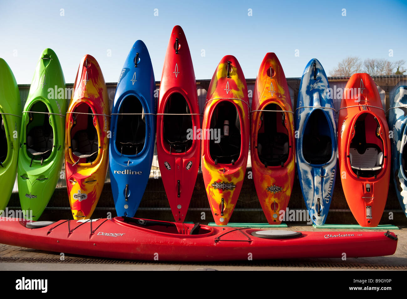 Fila de coloridos kayaks y canoas para la venta Ciudad Cardigan Ceredigion Gales Occidental UK Foto de stock
