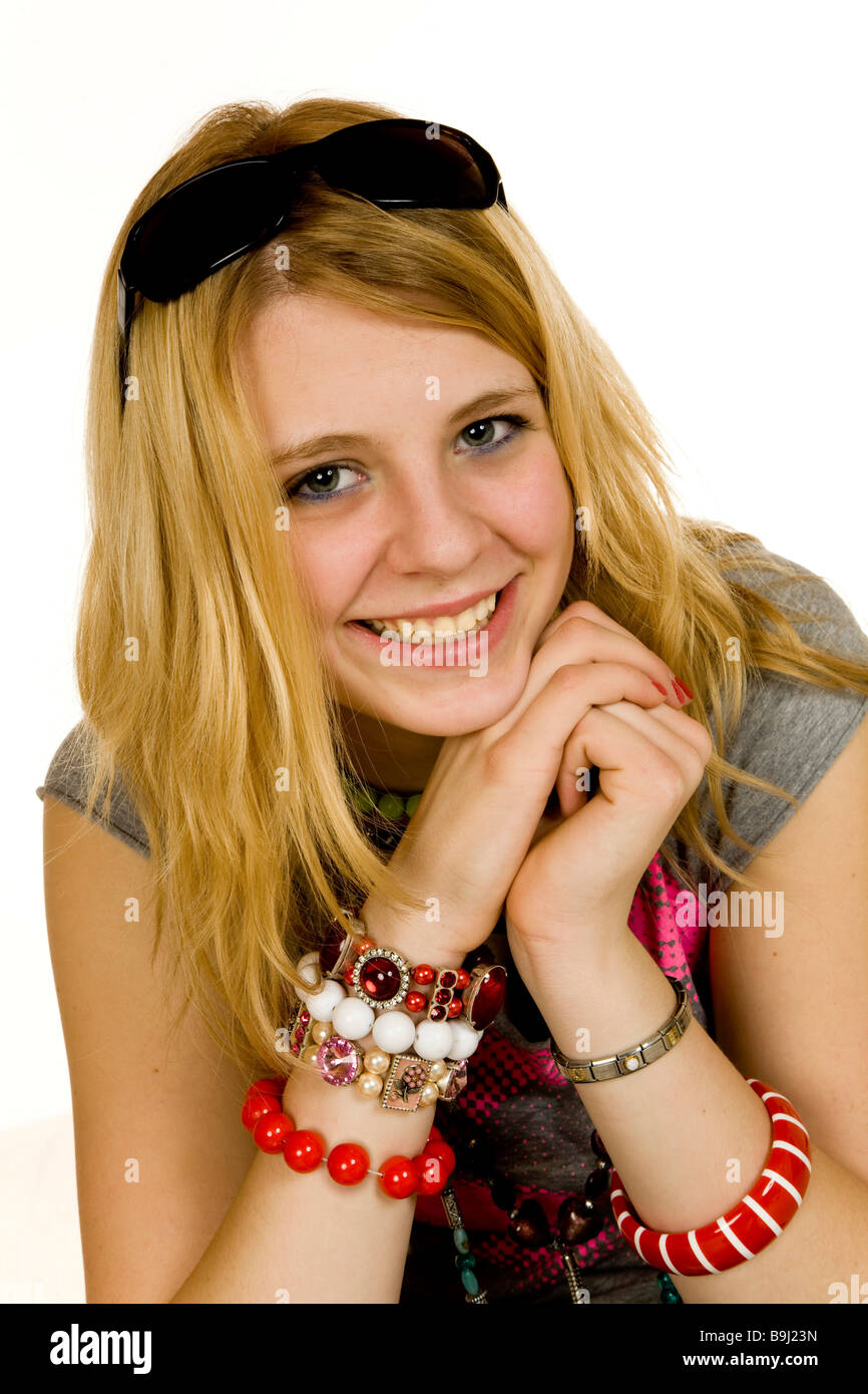 Retrato de una niña de 13 años vistiendo un montón de collares, pulseras, gafas de sol, empujado hacia arriba sobre su cabeza, sonriendo Foto de stock