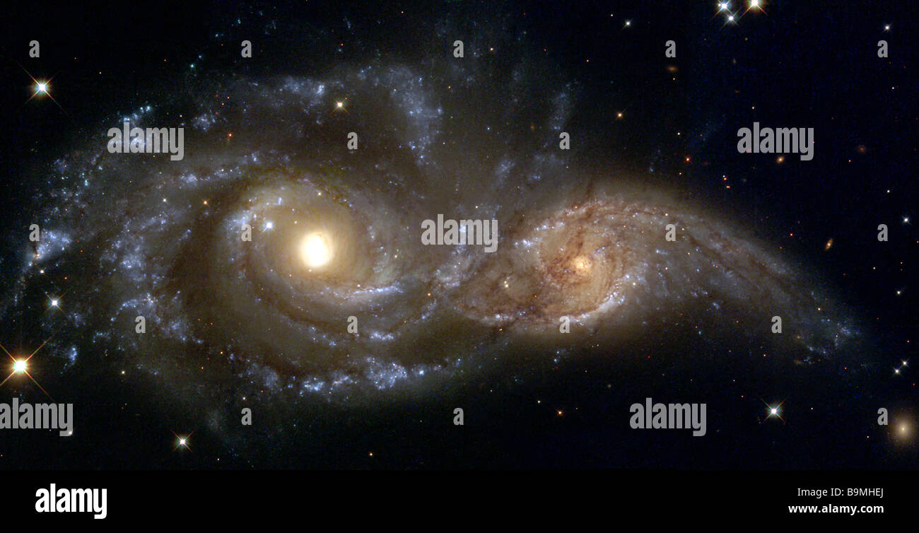 El más grande y más masivo está catalogado como la galaxia NGC 2207 en la parte izquierda de la imagen de Hubble Heritage y el pequeño un IC 2163 Foto de stock